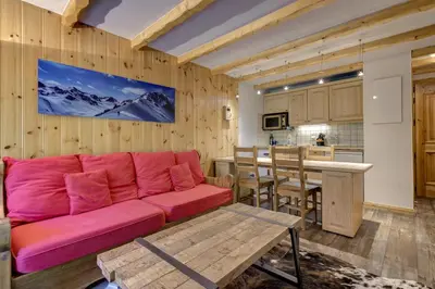 a living room with a red couch and a kitchen at Aiguilles Rouges - Apart 4pax Vues Terrasse Calme 50m Super U in Les Houches