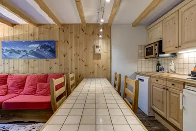 a living room with a red couch in a kitchen at Aiguilles Rouges - Apart 4pax Vues Terrasse Calme 50m Super U in Les Houches