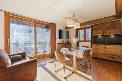 a living room with a table and a couch at Pecles - Apt 2CH Balcon Vue Gaillands 500m Centre 1km in Chamonix-Mont-Blanc
