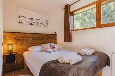 two beds in a bedroom with two towels at Pecles - Apt 2CH Balcon Vue Gaillands 500m Centre 1km in Chamonix-Mont-Blanc