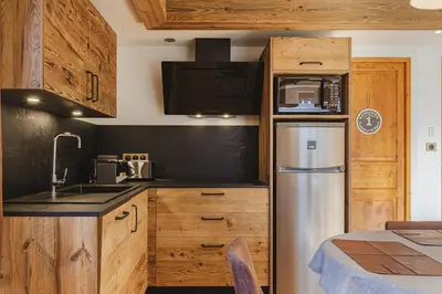 a kitchen with wooden cabinets and a refrigerator at Pecles - Apt 2CH Balcon Vue Gaillands 500m Centre 1km in Chamonix-Mont-Blanc