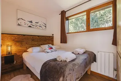 two beds in a bedroom with two towels at Pecles - Apt 2CH Balcon Vue Gaillands 500m Centre 1km in Chamonix-Mont-Blanc