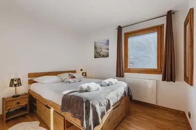 a bedroom with a bed with two towels on it at Pecles - Apt 2CH Balcon Vue Gaillands 500m Centre 1km in Chamonix-Mont-Blanc