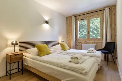 two beds in a room with a window at Hautes Aiguilles - Apart 2CH Vues Garage 5mn Grands Montets in Chamonix-Mont-Blanc