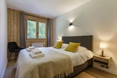 a bedroom with a large bed with towels on it at Hautes Aiguilles - Apart 2CH Vues Garage 5mn Grands Montets in Chamonix-Mont-Blanc