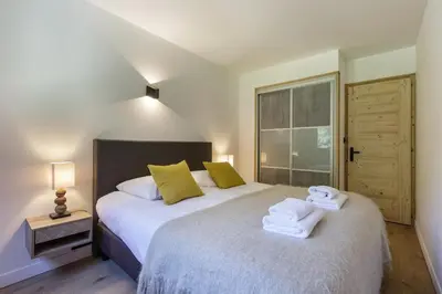 a bedroom with a bed with towels on it at Hautes Aiguilles - Apart 2CH Vues Garage 5mn Grands Montets in Chamonix-Mont-Blanc