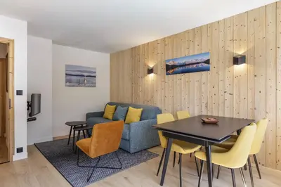a living room with a blue couch and a table at Hautes Aiguilles - Apart 2CH Vues Garage 5mn Grands Montets in Chamonix-Mont-Blanc