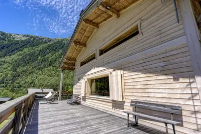 a wooden building with a bench on a deck at Le 111 - Chalet 4CH Calme Vue Pano 5mn Grands Montets in Chamonix-Mont-Blanc