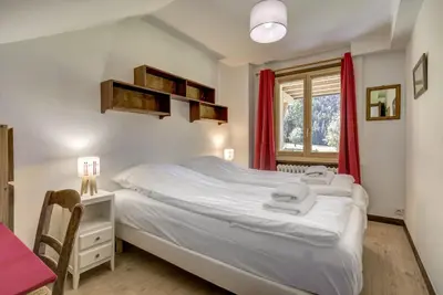 a bedroom with a bed and a desk and a window at Le 111 - Chalet 4CH Calme Vue Pano 5mn Grands Montets in Chamonix-Mont-Blanc