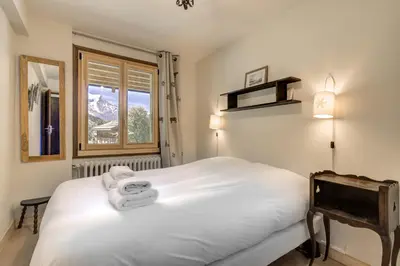 a bedroom with a white bed and a window at Le 111 - Chalet 4CH Calme Vue Pano 5mn Grands Montets in Chamonix-Mont-Blanc