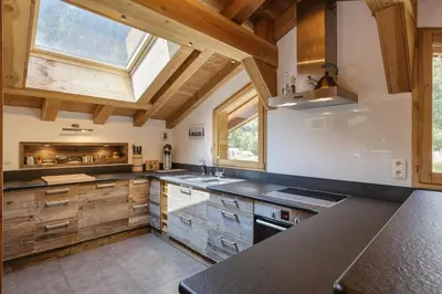 a large kitchen with wooden cabinets and a window at Whisky - Chalet 150m2 Calme Sauna Jacuzzi in Chamonix-Mont-Blanc