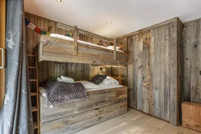 a bedroom with a wooden wall with a bed in it at Whisky - Chalet 150m2 Calme Sauna Jacuzzi in Chamonix-Mont-Blanc