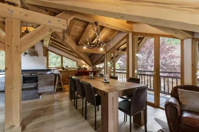 a kitchen and dining room with a wooden table and chairs at Whisky - Chalet 150m2 Calme Sauna Jacuzzi in Chamonix-Mont-Blanc