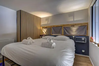 a bedroom with a large white bed with towels on it at Fontanes - Duplex 200m Grands Montets Balcon Vue Parking in Chamonix-Mont-Blanc