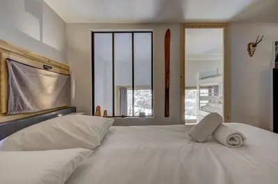 a bedroom with a large white bed with windows at Fontanes - Duplex 200m Grands Montets Balcon Vue Parking in Chamonix-Mont-Blanc