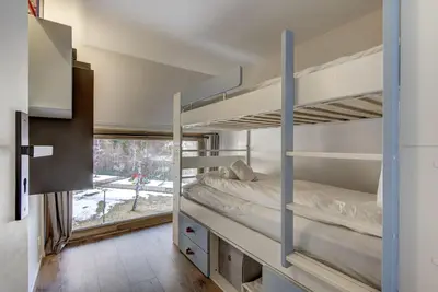 a room with two bunk beds and a window at Fontanes - Duplex 200m Grands Montets Balcon Vue Parking in Chamonix-Mont-Blanc