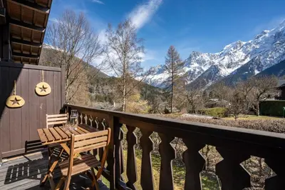 a balcony with a table and a view of mountains at Namaste - Cosy 2CH Vue Remontee 500m Parking in Les Houches