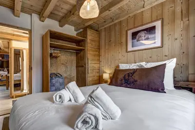 a bedroom with a large bed with wooden walls at Namaste - Cosy 2CH Vue Remontee 500m Parking in Les Houches