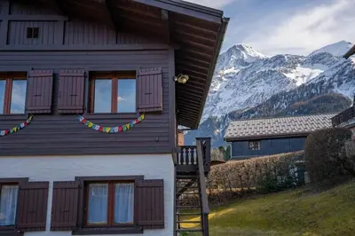 a house with purple windows and a snow covered mountain at Namaste - Cosy 2CH Vue Remontee 500m Parking in Les Houches