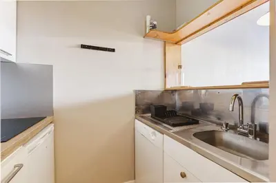 a kitchen with white cabinets and a sink at Chamois - Cosy 3pax Centre Vue Parking Gare routiere in Chamonix-Mont-Blanc