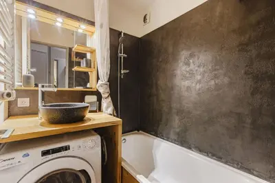 a bathroom with a tub and a washing machine at Chamois - Cosy 3pax Centre Vue Parking Gare routiere in Chamonix-Mont-Blanc
