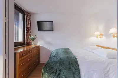 a bedroom with a bed and a television on the wall at Chamois - Cosy 3pax Centre Vue Parking Gare routiere in Chamonix-Mont-Blanc