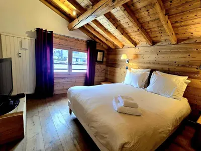 a bedroom with a large bed in a log cabin at Charming duplex in Hameau des Pistes ski in ski out in Megève
