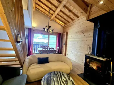 a living room with a couch and a fireplace at Charming duplex in Hameau des Pistes ski in ski out in Megève