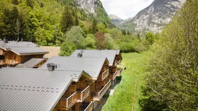 an aerial view of a building with mountains in the background at Demi-chalet meublé de tourisme 4 étoiles in Samoëns