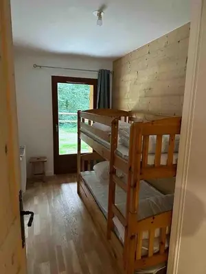 a room with two bunk beds and a window at Demi-chalet meublé de tourisme 4 étoiles in Samoëns