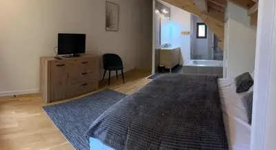a bedroom with a bed and a dresser with a television at Demi-chalet meublé de tourisme 4 étoiles in Samoëns