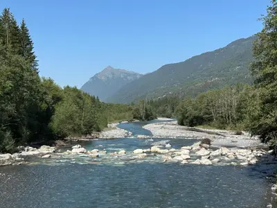 a river with rocks and mountains in the background at Demi-chalet meublé de tourisme 4 étoiles in Samoëns