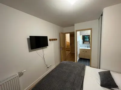 a bedroom with a bed with a flat screen tv on the wall at Demi-chalet meublé de tourisme 4 étoiles in Samoëns