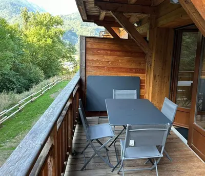 a table and chairs on the balcony of a cabin at Demi-chalet meublé de tourisme 4 étoiles in Samoëns