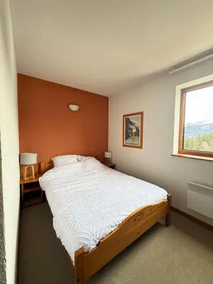 a bedroom with a large bed and a window at Appartement face aux pistes Morillon 1100 in Morillon