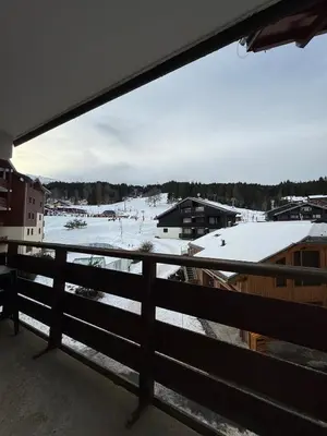 a view of a snow covered field from a balcony at Appartement face aux pistes Morillon 1100 in Morillon
