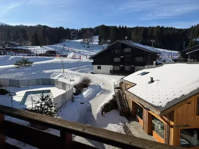 a ski lodge with snow on the roofs of buildings at Appartement face aux pistes Morillon 1100 in Morillon