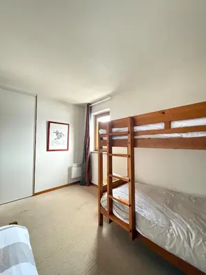 a bedroom with two bunk beds and a window at Appartement face aux pistes Morillon 1100 in Morillon
