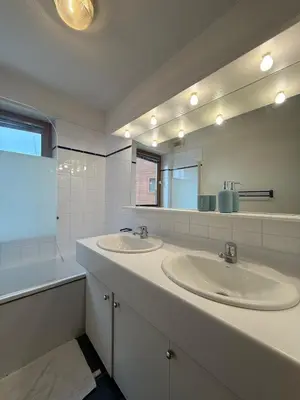 a bathroom with two sinks and a large mirror at Appartement face aux pistes Morillon 1100 in Morillon