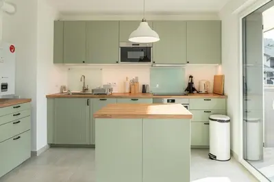 a kitchen with green cabinets and a counter top at Apartment Le Valleen in Saint-Gervais-les-Bains