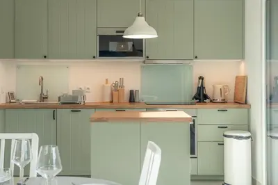 a kitchen with green cabinets and a counter top at Apartment Le Valleen in Saint-Gervais-les-Bains