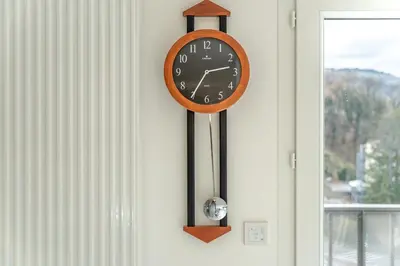 a clock hanging on a wall next to a window at Apartment Le Valleen in Saint-Gervais-les-Bains