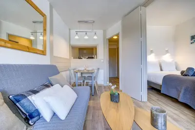 a living room with a couch and a bed and a table at Bouquetin - Cosy 2pax Centre Vue Parking Gare routiere in Chamonix-Mont-Blanc