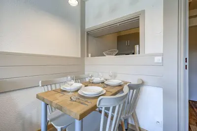 a dining room with a wooden table and chairs at Bouquetin - Cosy 2pax Centre Vue Parking Gare routiere in Chamonix-Mont-Blanc