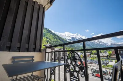 a balcony with a table and a view of a city at Bouquetin - Cosy 2pax Centre Vue Parking Gare routiere in Chamonix-Mont-Blanc