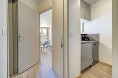 a kitchen with white cabinets and a door leading into a room at Bouquetin - Cosy 2pax Centre Vue Parking Gare routiere in Chamonix-Mont-Blanc