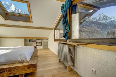 a bedroom with a bed and a large window at Lac - Cosy 120m2 Vues MtBlanc Flegere 5mn Lac Golf in Chamonix-Mont-Blanc