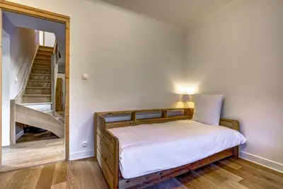 a bedroom with a bed with a staircase in the background at Lac - Cosy 120m2 Vues MtBlanc Flegere 5mn Lac Golf in Chamonix-Mont-Blanc