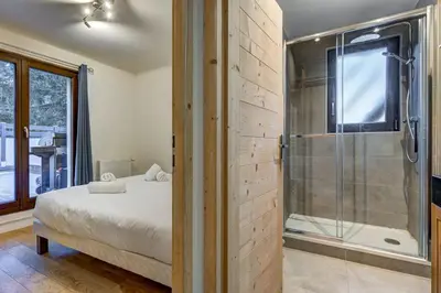 a bedroom with a bed and a glass shower at Lac - Cosy 120m2 Vues MtBlanc Flegere 5mn Lac Golf in Chamonix-Mont-Blanc