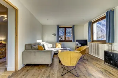 a living room with a couch and a table and chairs at Lac - Cosy 120m2 Vues MtBlanc Flegere 5mn Lac Golf in Chamonix-Mont-Blanc